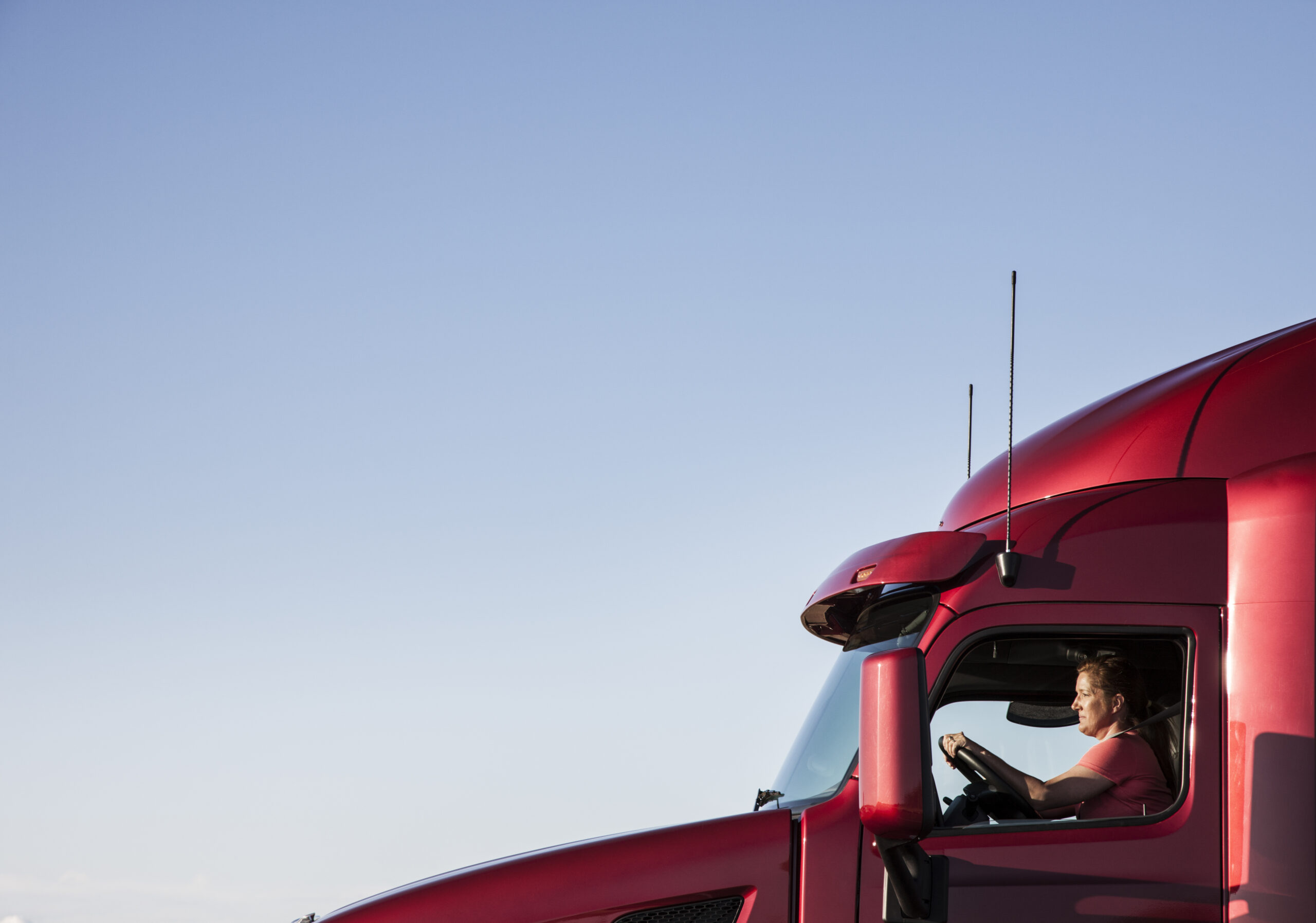 View of a Caucasian woman driver in the cab of her  commercial truck.