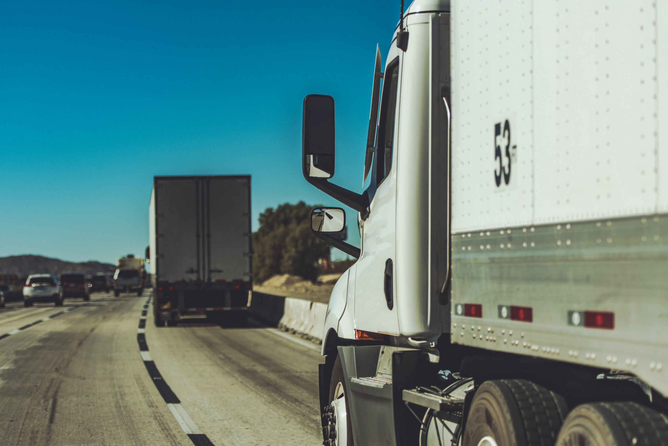 Semi Trucks Convoy on a California Highway. Heavy Duty American Transportation Industry.